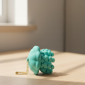 Light blue articulated jellyfish keychain on wooden desk