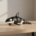 Black and white articulated orca whale on wooden desk
