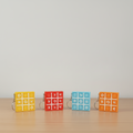 Tic-tac-toe keychains in yellow, red, light blue, and orange on desk